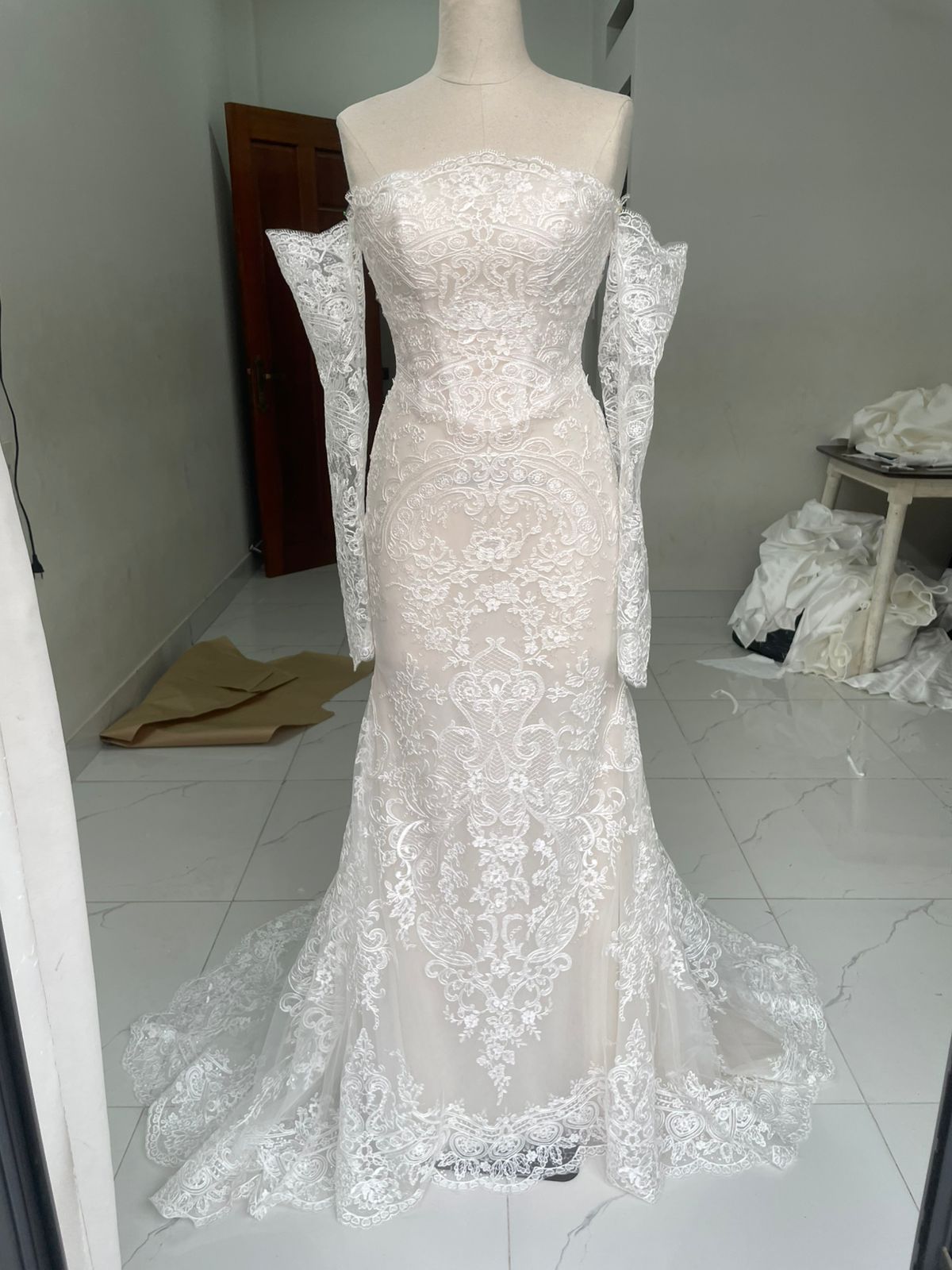 Premium Alencon lace mermaid wedding dress with dramatic neckline and off-shoulder sleeve styling, custom-made by VI Dressmakers Vietnam before Germany delivery