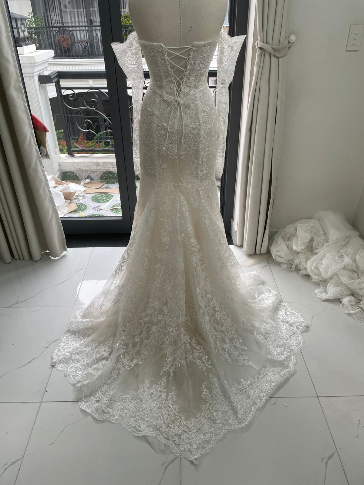 Final back QC of Franziska's Alencon lace mermaid dress showing corset lacing, sleeves, and train
